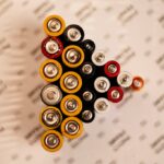 Top view of assorted batteries in an artistic arrangement on a printed surface.