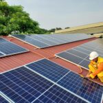 A solar technician performs maintenance on rooftop solar panels enhancing energy efficiency.