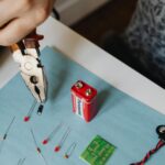 Close-up of electronics repair using pliers with resistors and battery.