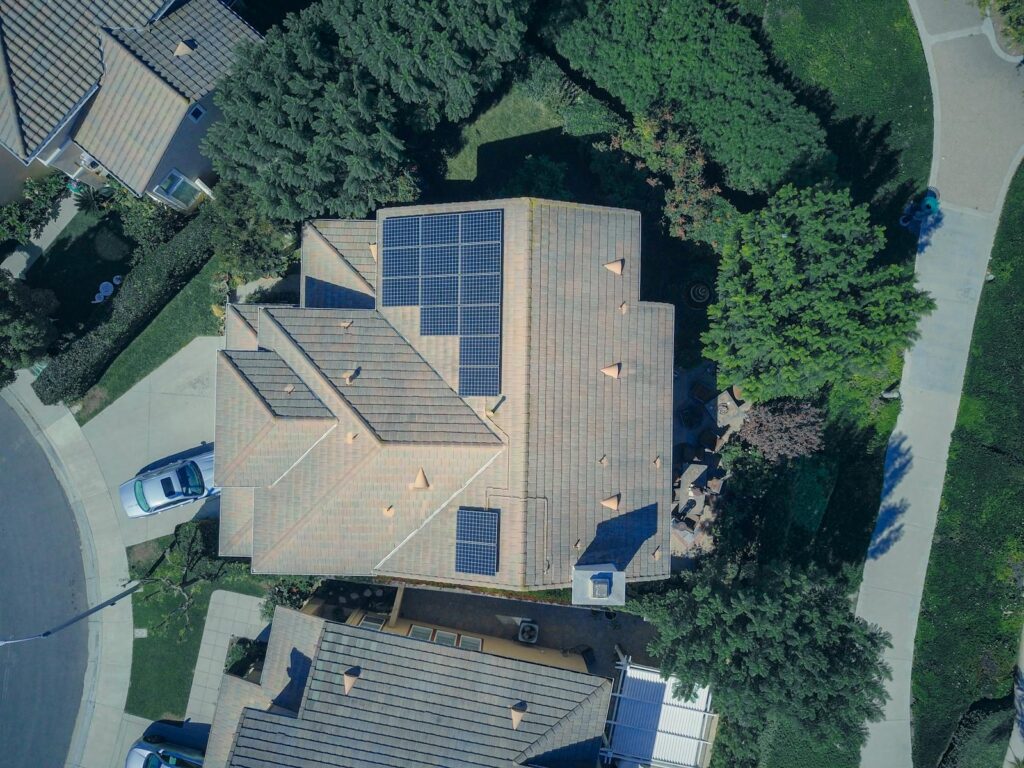 Top-down aerial view of a house with solar panels, showcasing modern renewable energy solutions.